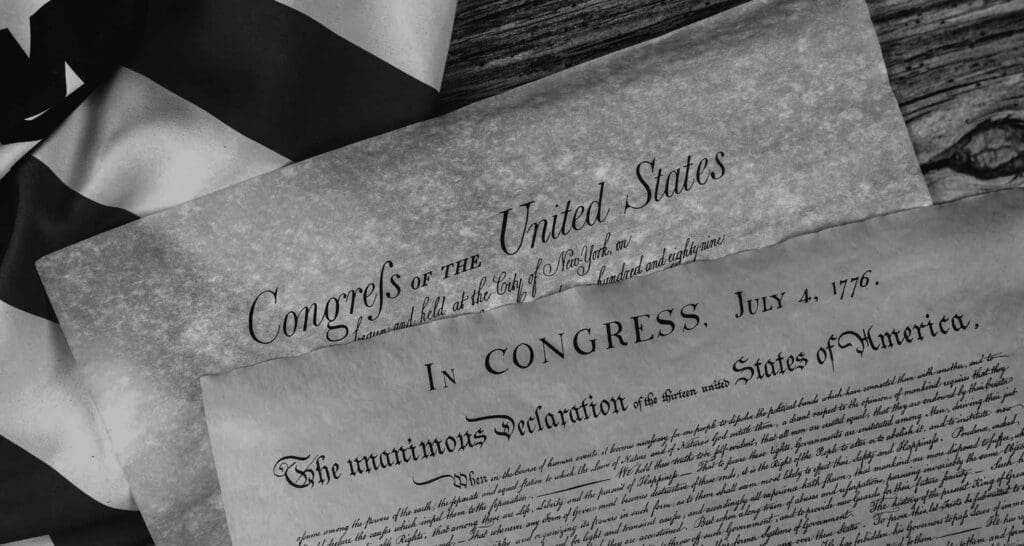 Copies of Declaration of Independence and US Constitution with US flag laying underneath